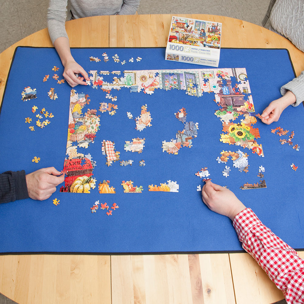 People building a puzzle on the puzzle mat.